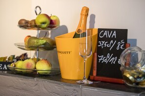 Ein Getränkestand mit einer Champagnerflasche, einem Glas und einem Preisschild für Cava.