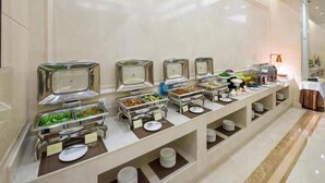 Montaje de bufé con varias estaciones de comida y utensilios para servir.