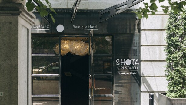 The entrance to the Boutique Hotel Rustaveli, featuring a modern design with glass doors and a visible sign. - Shota@Rustaveli Boutique hotel (Tbilisi)