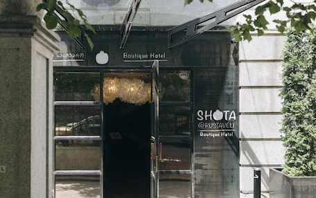 The entrance to the Boutique Hotel Rustaveli, featuring a modern design with glass doors and a visible sign.