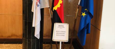 A hotel lobby with a sign reading "HOTEL GOLDEN PARK" and flags of different countries.
