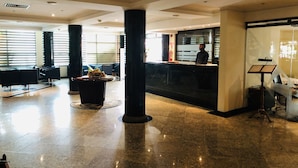 A spacious lobby with a reception desk, seating area, and a piano. - Golden Park Hotel (Luanda)