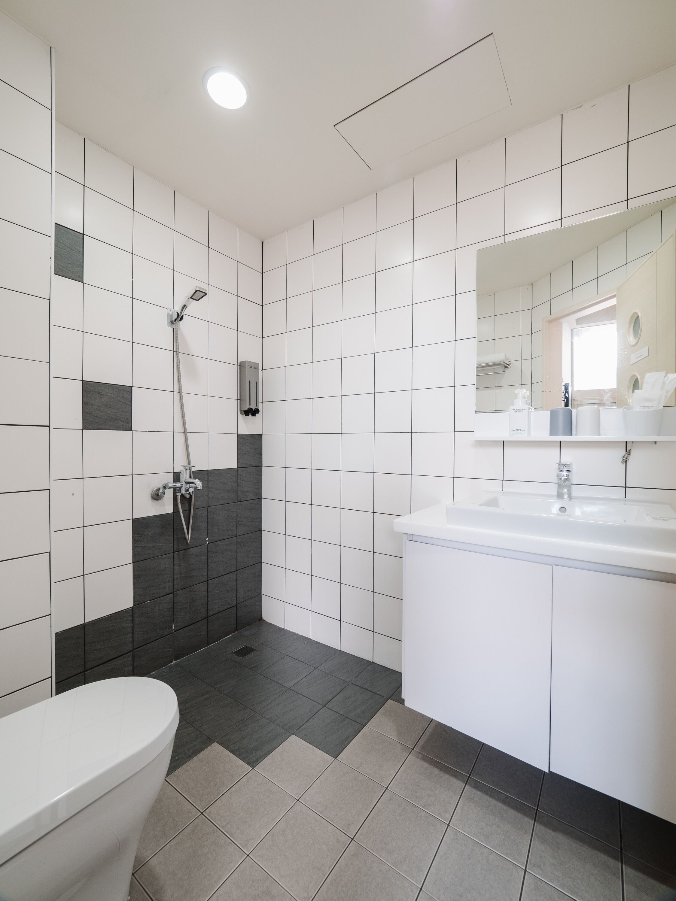 A modern bathroom with a toilet, sink, and shower.