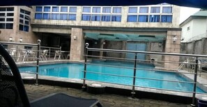 室外游泳池，池畔遮阳伞，日光浴躺椅