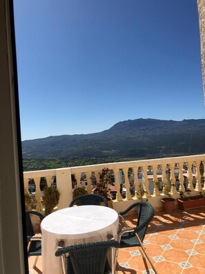 A balcony with a round table and chairs, overlooking a mountainous landscape. - Mina House (Chefchaouen)