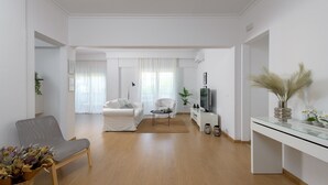 A spacious living room with a sofa, a chair, a coffee table, and a TV.