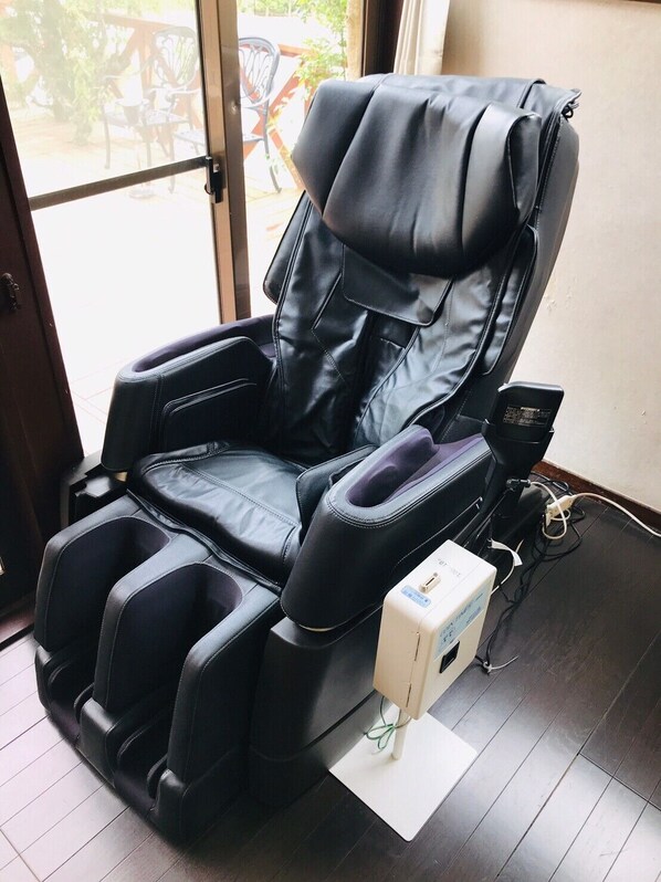 Una silla de masajes con su unidad de control a un lado.