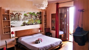 Ein Schlafzimmer mit einem großen Bett, einem hölzernen Kopfende, einem roten Sessel, einem Schrank aus Holz und einem Bild an der Wand.