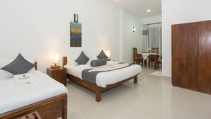 Een hotelkamer met twee bedden, een houten garderobe, een zithoek en een schilderij aan de muur.