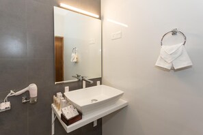 A modern bathroom with a white sink, a hairdryer, and a towel rack. - Grand Camellia (Nuwara Eliya)