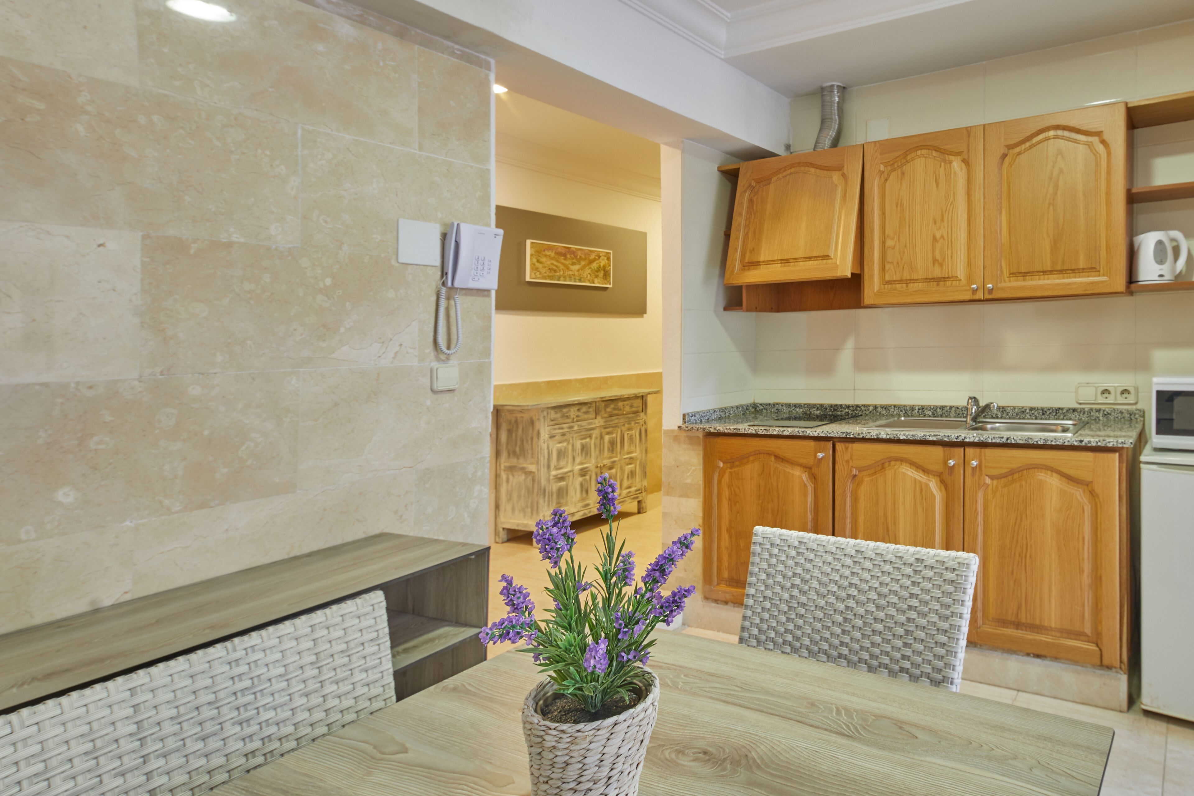 Una cocina moderna con armarios de madera, encimera de granito y horno empotrado.