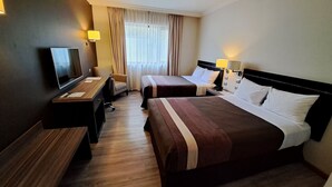 A hotel room with two beds, a desk, a TV, and a window with curtains. - Hotel Diego de Almagro Osorno (Osorno)