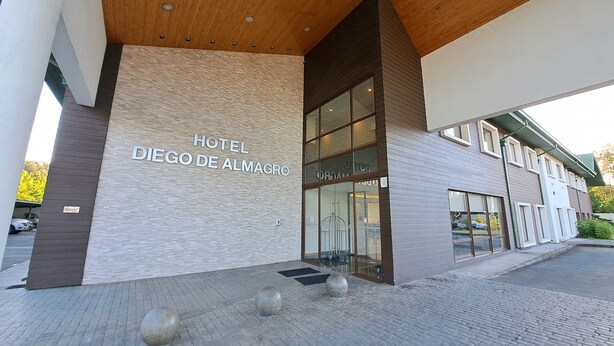 The exterior of Hotel Diego de Almagro with a modern facade, large glass entrance, and a paved entrance area with bollards. - Hotel Diego de Almagro Osorno (Osorno)
