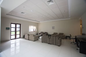 A spacious room with a large window, a sofa set, a desk, and a chair. - Hotel Diego de Almagro Osorno (Osorno)