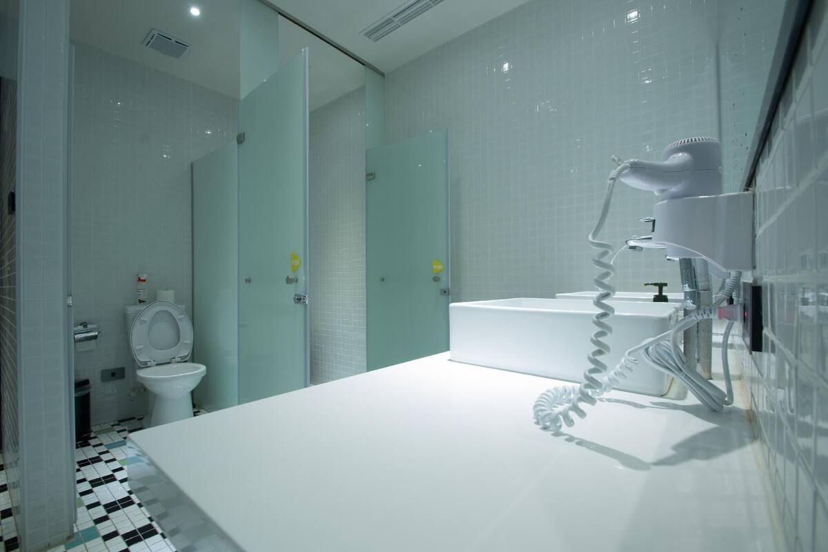 Une salle de bain moderne avec un lavabo blanc, une douche en verre et des toilettes.