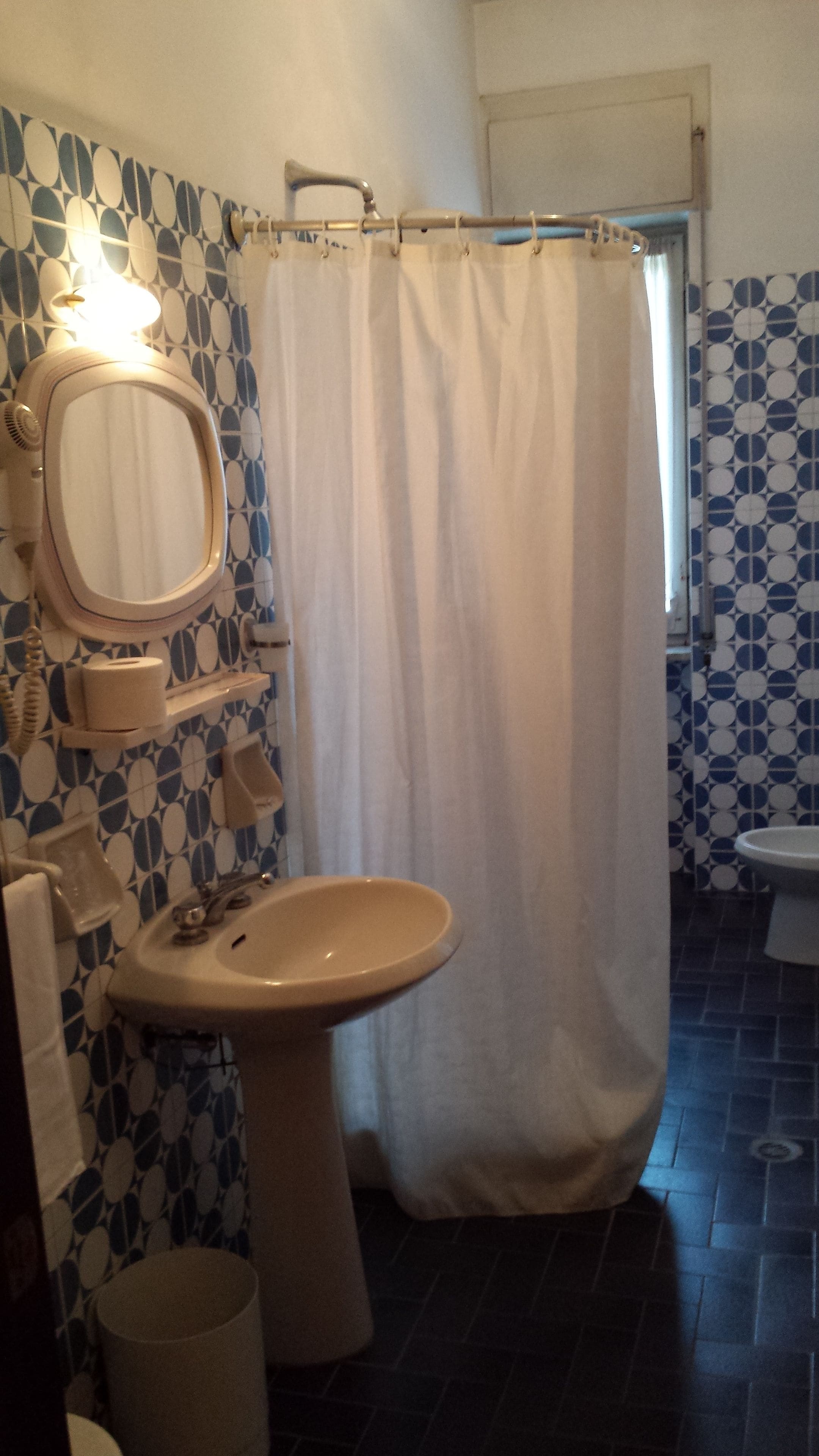A bathroom with a sink, mirror, and shower curtain.