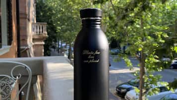 Una bottiglia d'acqua nera con scritte su un balcone.