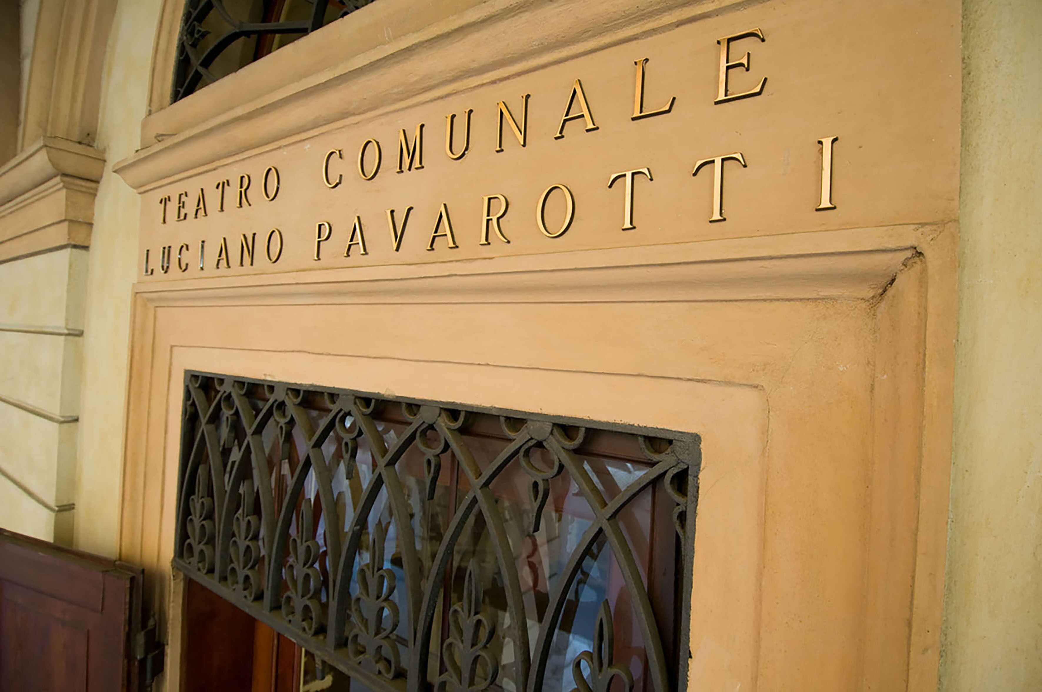 Ein Schild für das Teatro Comunale Luciano Pavarotti I, das den Namen eines Theaters angibt.