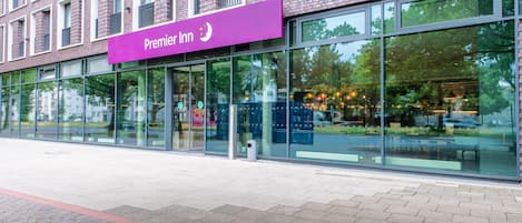 A hotel with a prominent 'Premier Inn' sign, large windows, and a brick facade.