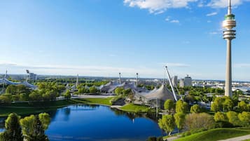 Una vista panoramica di una città con una torre imponente, un lago e architettura moderna.