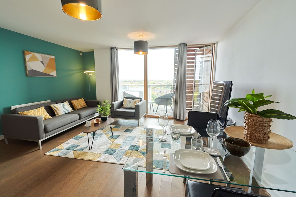 A modern living room with a sofa, coffee table, and dining area.