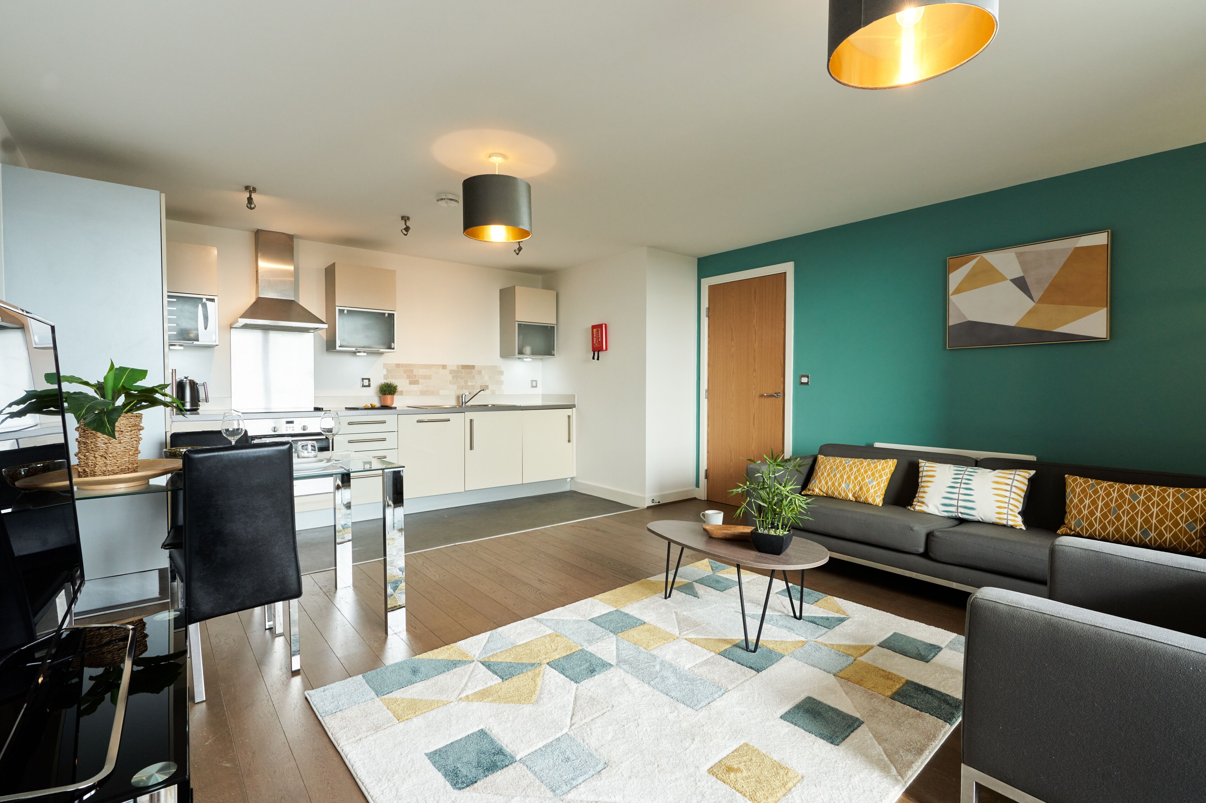 A modern living room with a sofa, coffee table, and a dining area with chairs and a table.