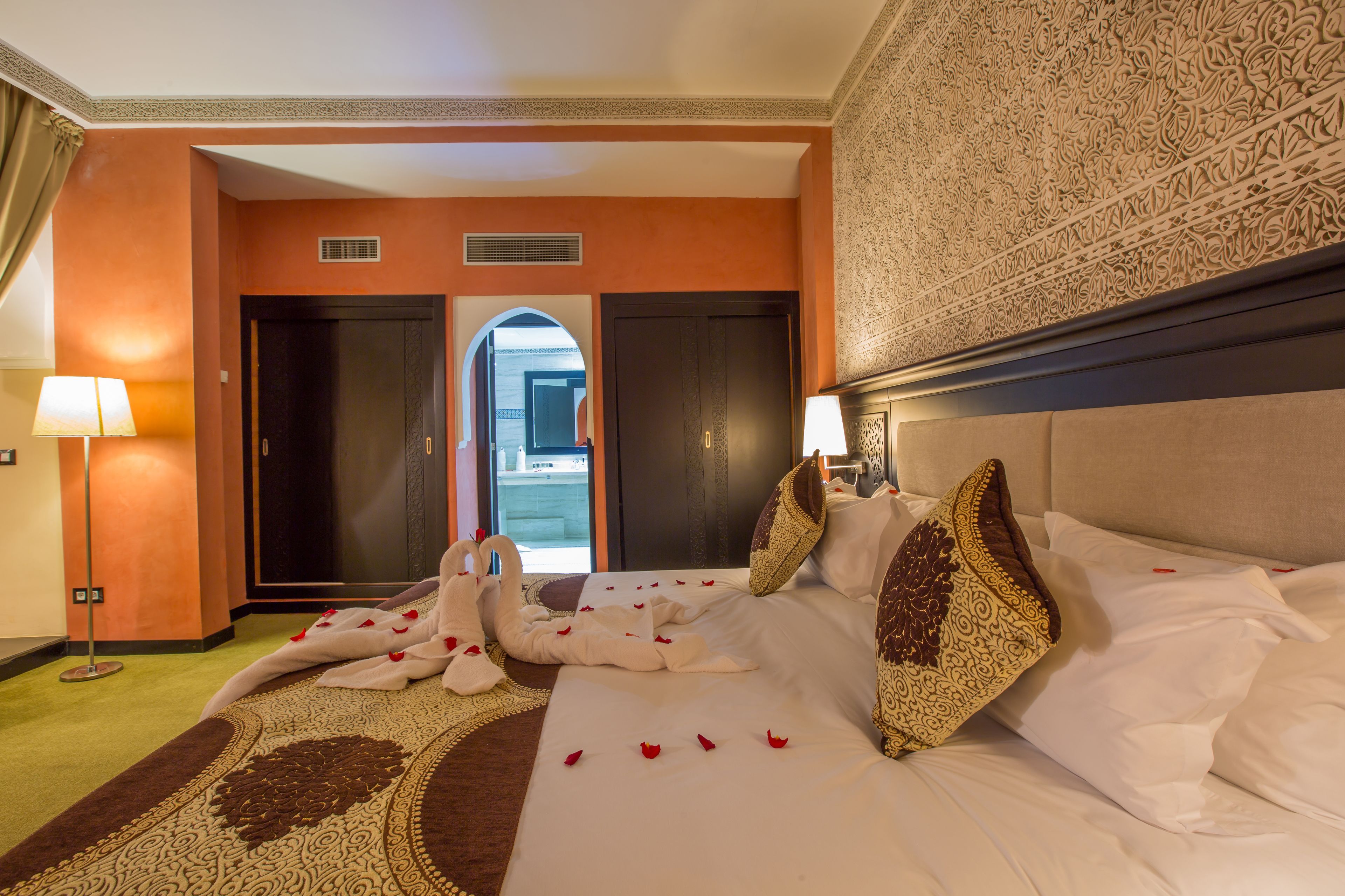 Habitación de hotel con cama, almohadas, alfombra y vistas al exterior.