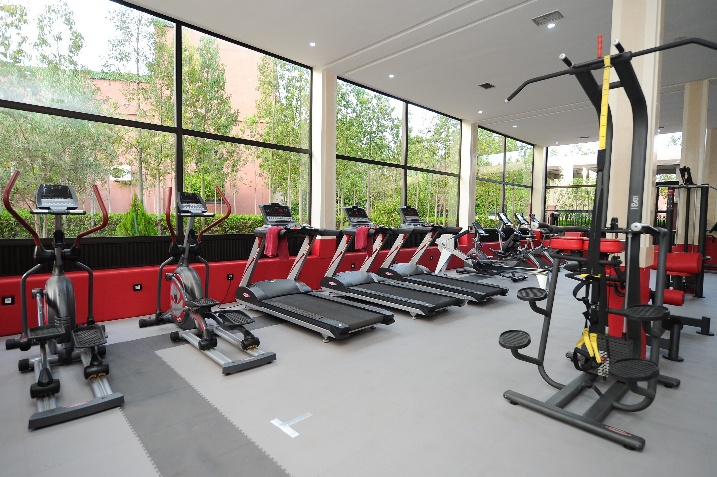 A gym with multiple treadmills, ellipticals, and weight machines.