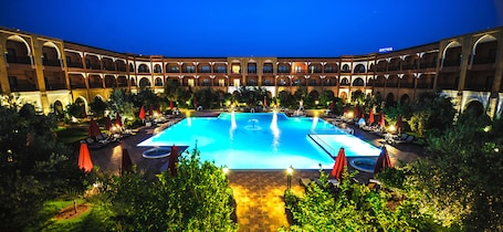 Indoor pool, outdoor pool, pool umbrellas, pool loungers. Ennakhil Marrakech Hotel & SPA