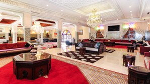 A spacious lobby with a red carpet, multiple seating areas, and a grand chandelier. - Ennakhil Marrakech Hotel & SPA (Marrakech)