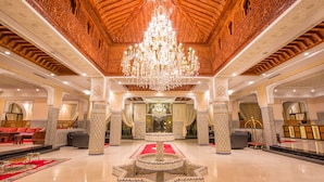 A grand lobby with a large chandelier, ornate columns, and a central fountain. - Ennakhil Marrakech Hotel & SPA (Marrakech)