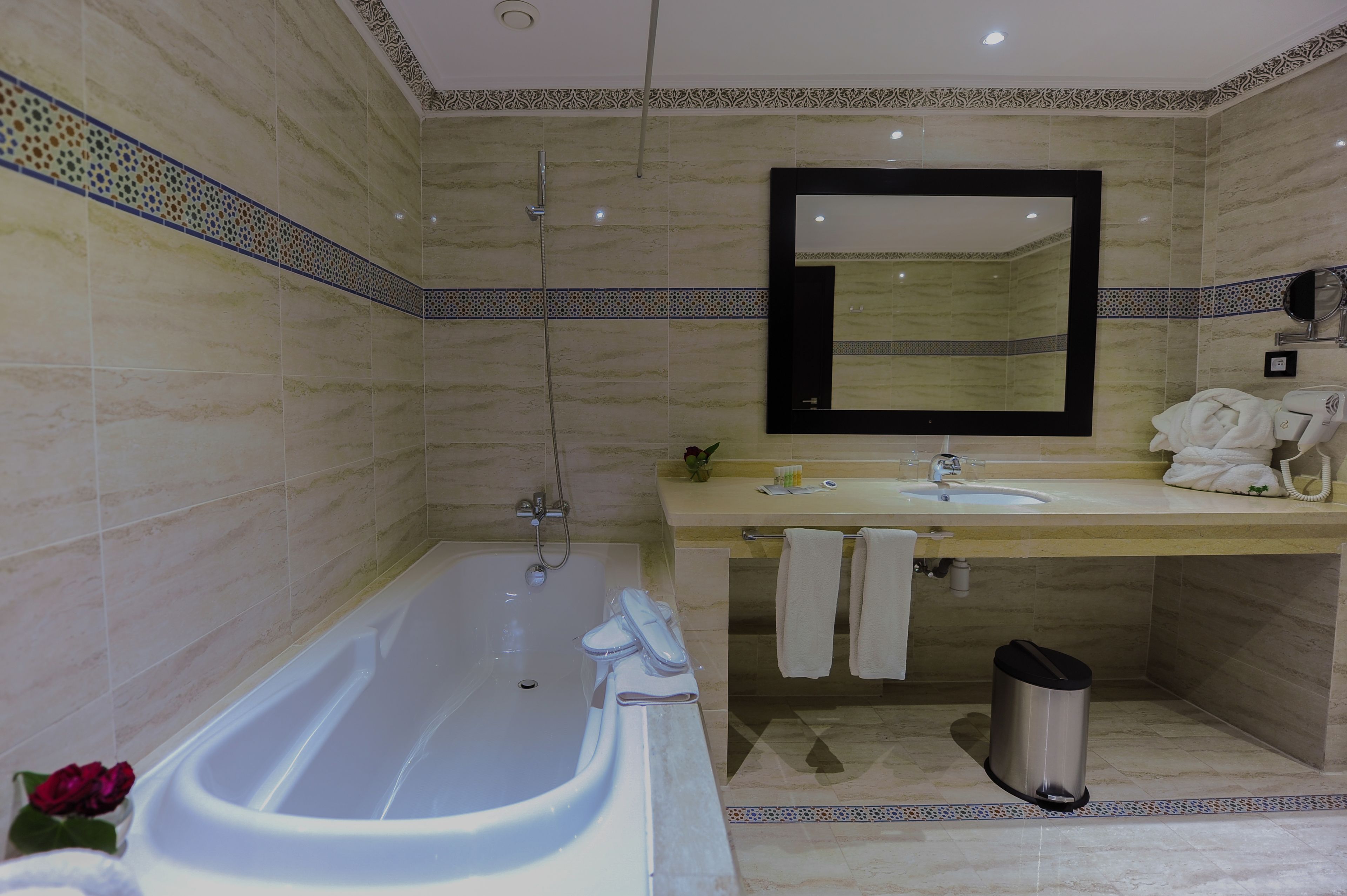 A bathroom with a bathtub, sink, and mirror.