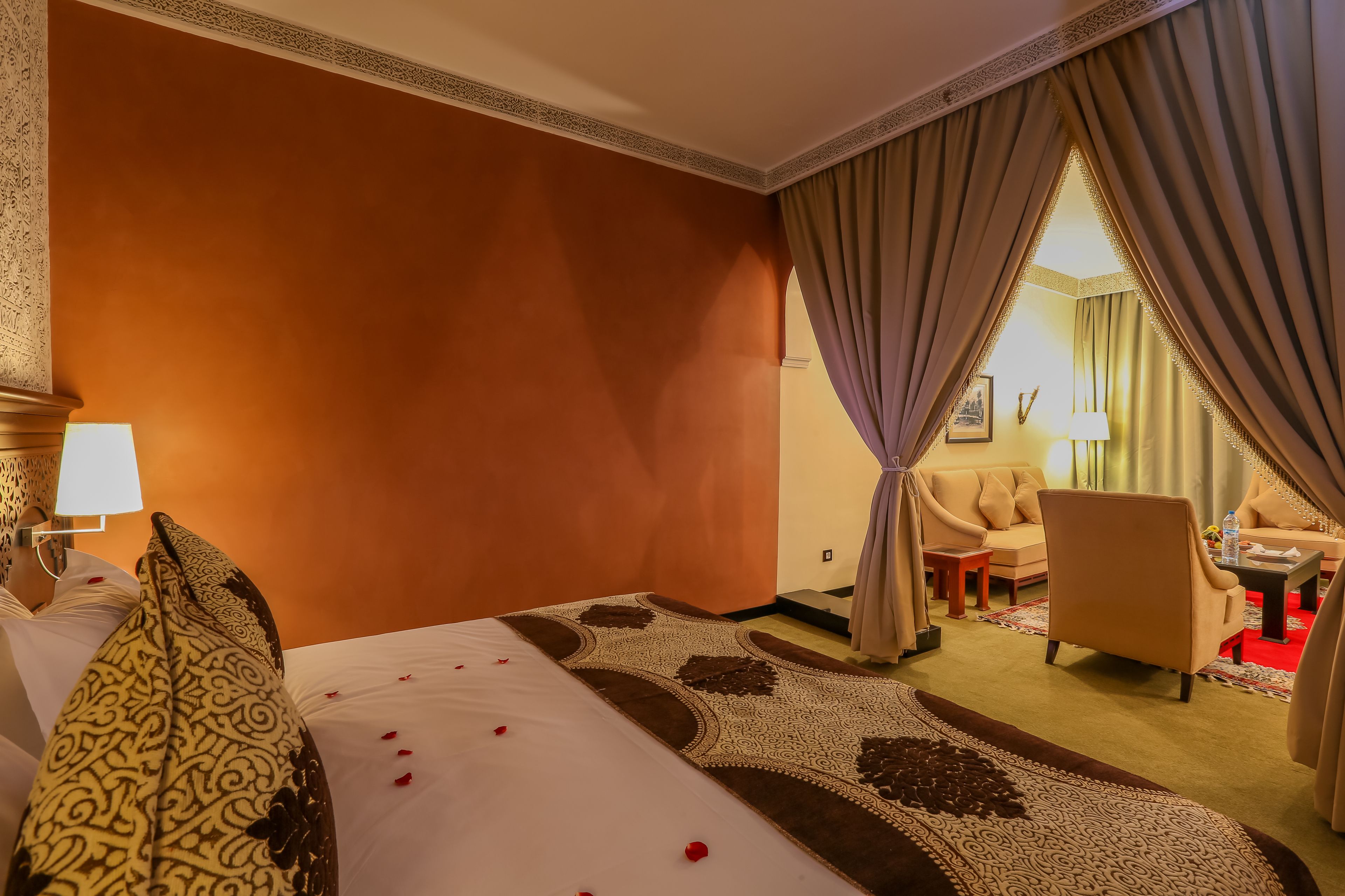 Une chambre d’hôtel avec un lit, un canapé, une chaise et une petite table.