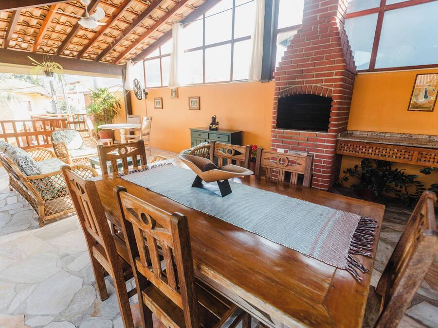 Una mesa de comedor de madera con sillas, una chimenea de ladrillo y un suelo de piedra.