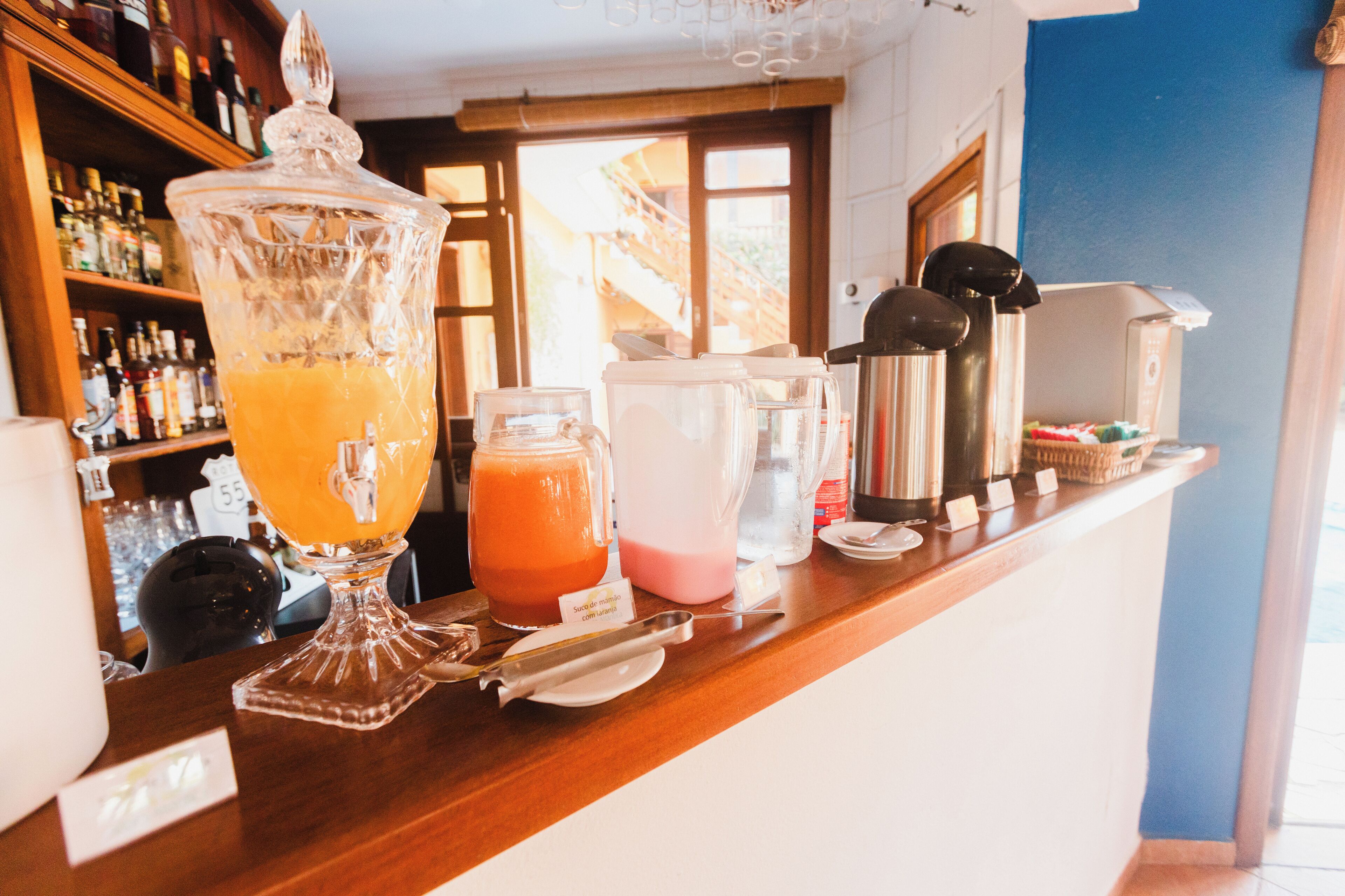 Un área de bar con un gran bol de vidrio para ponche, una licuadora y una máquina de café.