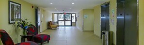 A hotel corridor with a reception area, a fitness center sign, and a trash bin. - Holiday Inn Fort Myers - Downtown Area by IHG (Fort Myers)