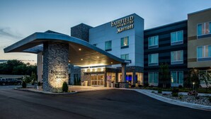 Entrada de un hotel Fairfield Inn & Suites Marriott con fachada de piedra, ventanas amplias y un alero curvo.