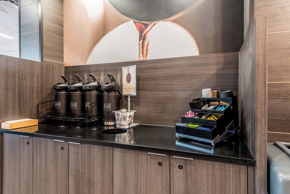 Une cuisine moderne dotée d’un espace dédié au café, comprenant quatre machines à café et une cafetière.