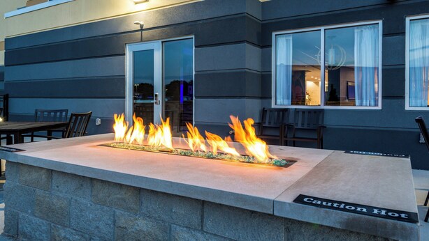 Una chimenea con una señal de precaución, una puerta de cristal y zona de estar exterior.