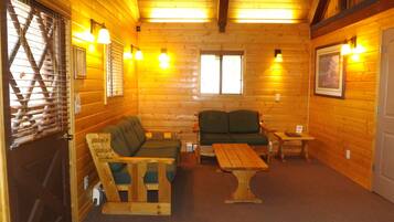A cozy log cabin interior with a wooden bench, a sofa, and a table.