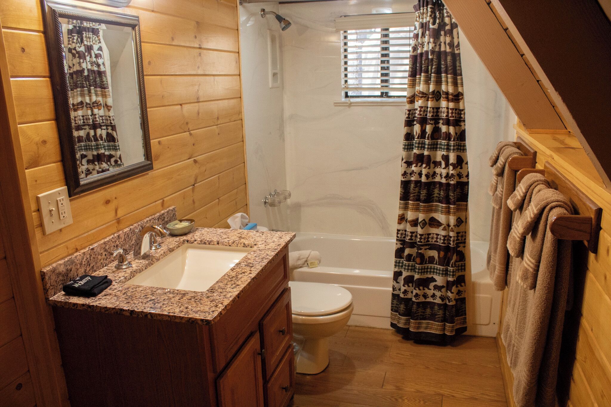 Ein Badezimmer einer Holzhütte mit Waschbecken, Toilette und Badewanne.