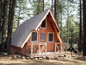 A cabin with a gabled roof, numbered 19, surrounded by trees. - Arizona Mountain Inn and Cabins (Flagstaff)