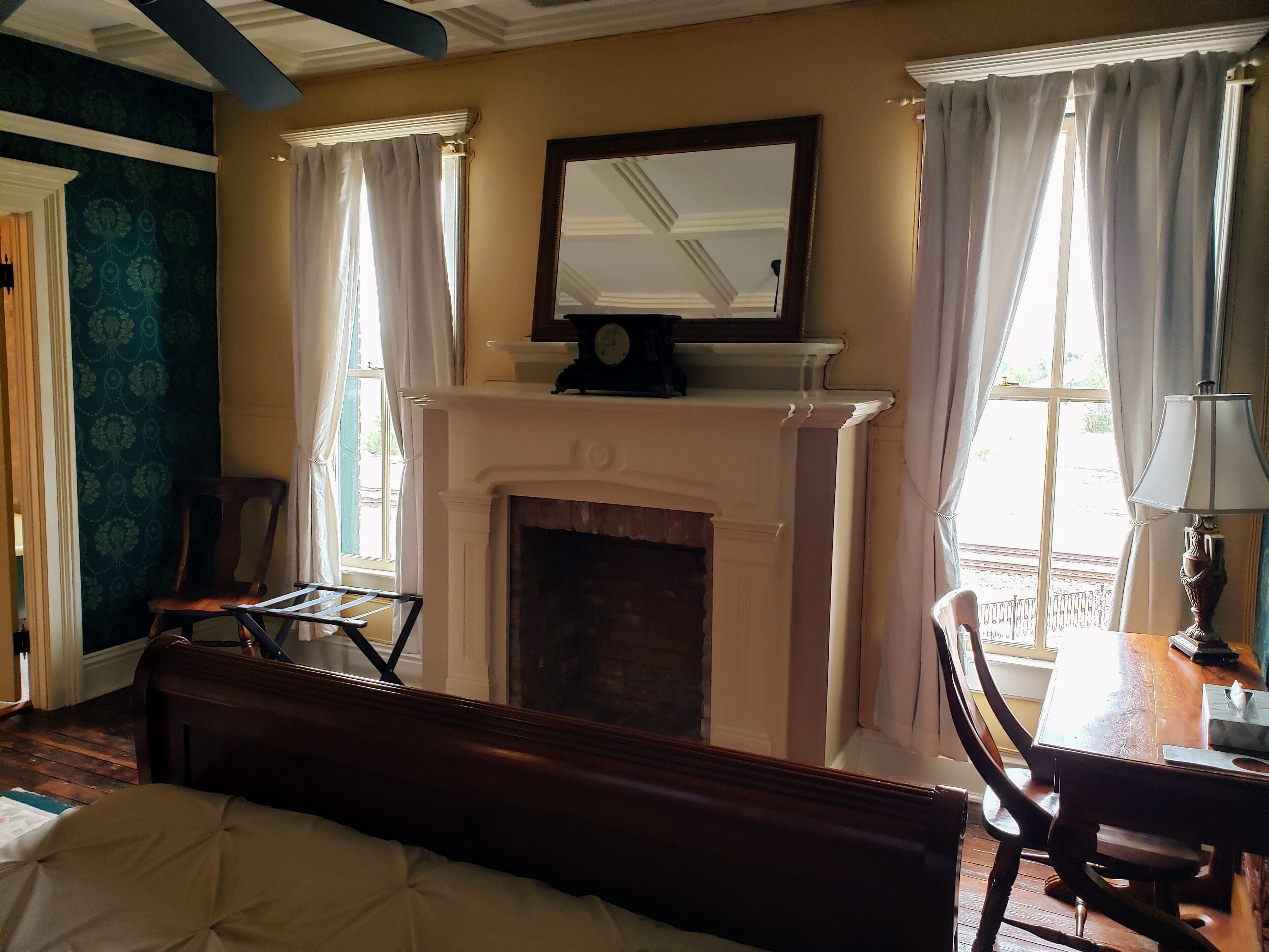 A room with a fireplace, a bed, a table, and a chair.