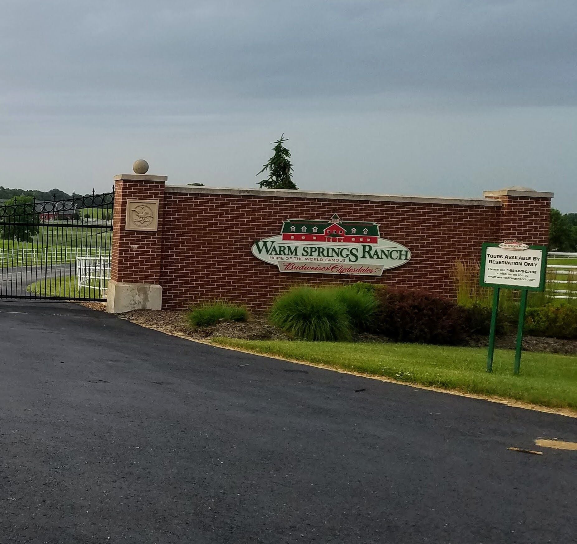 A brick wall with a sign for Warm Springs Ranch, a Budweiser Cluesdales location.