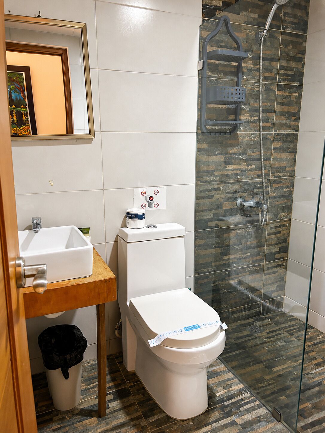 A bathroom with a toilet, sink, and shower.