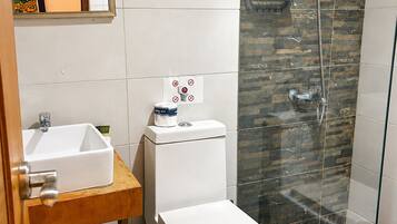 A bathroom with a toilet, sink, and shower.
