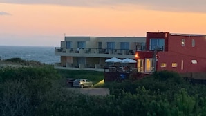 En byggnad vid kusten med flera balkonger som vetter mot havet.