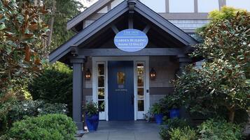 Un bâtiment avec une enseigne indiquant « Bâtiment des jardins, chambres 13 à 22 » à l’entrée.
