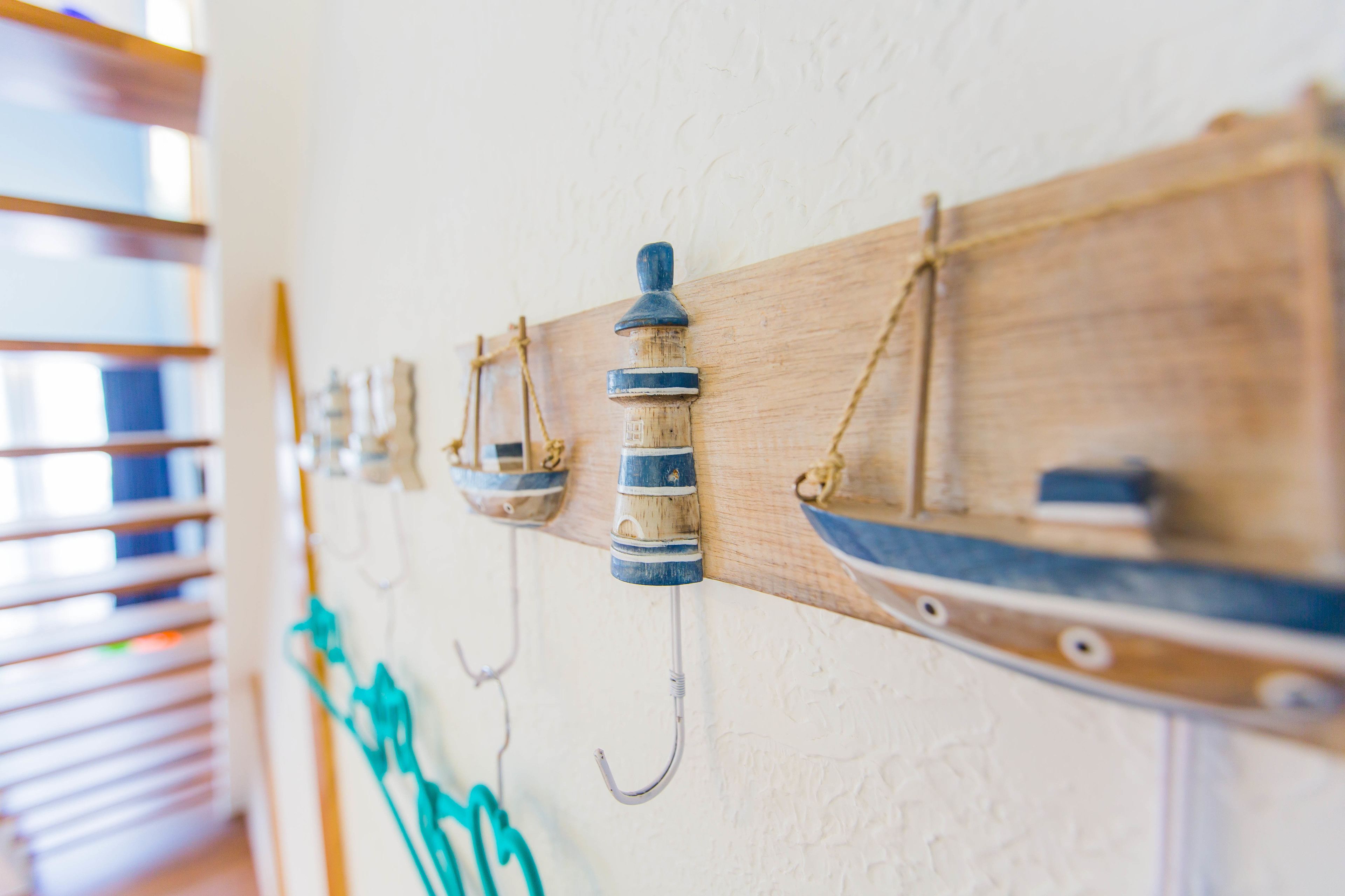 A wall-mounted wooden rack with multiple hooks and a shelf.