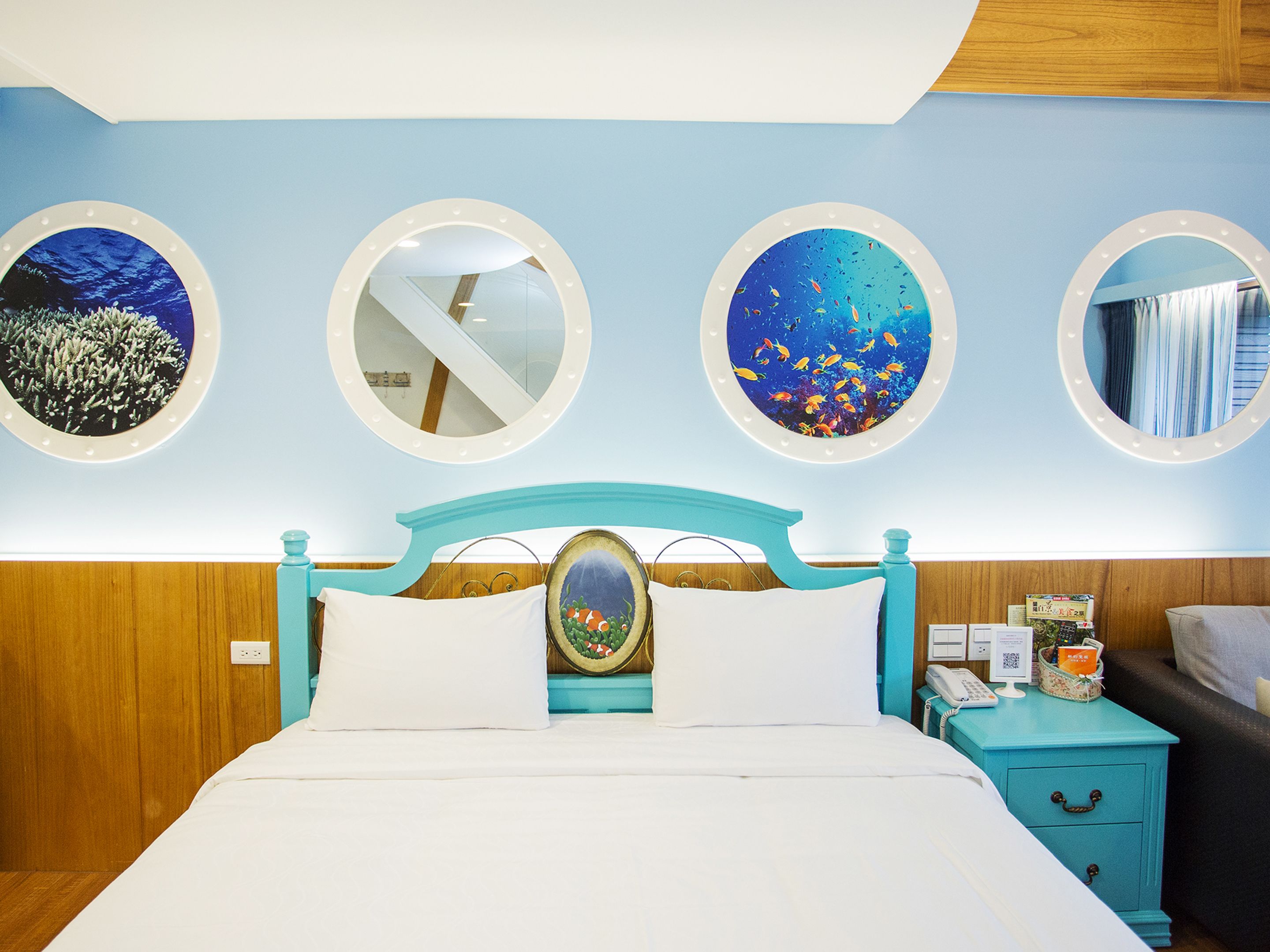 A neatly arranged hotel room with a bed, a nightstand, and three wall-mounted mirrors.
